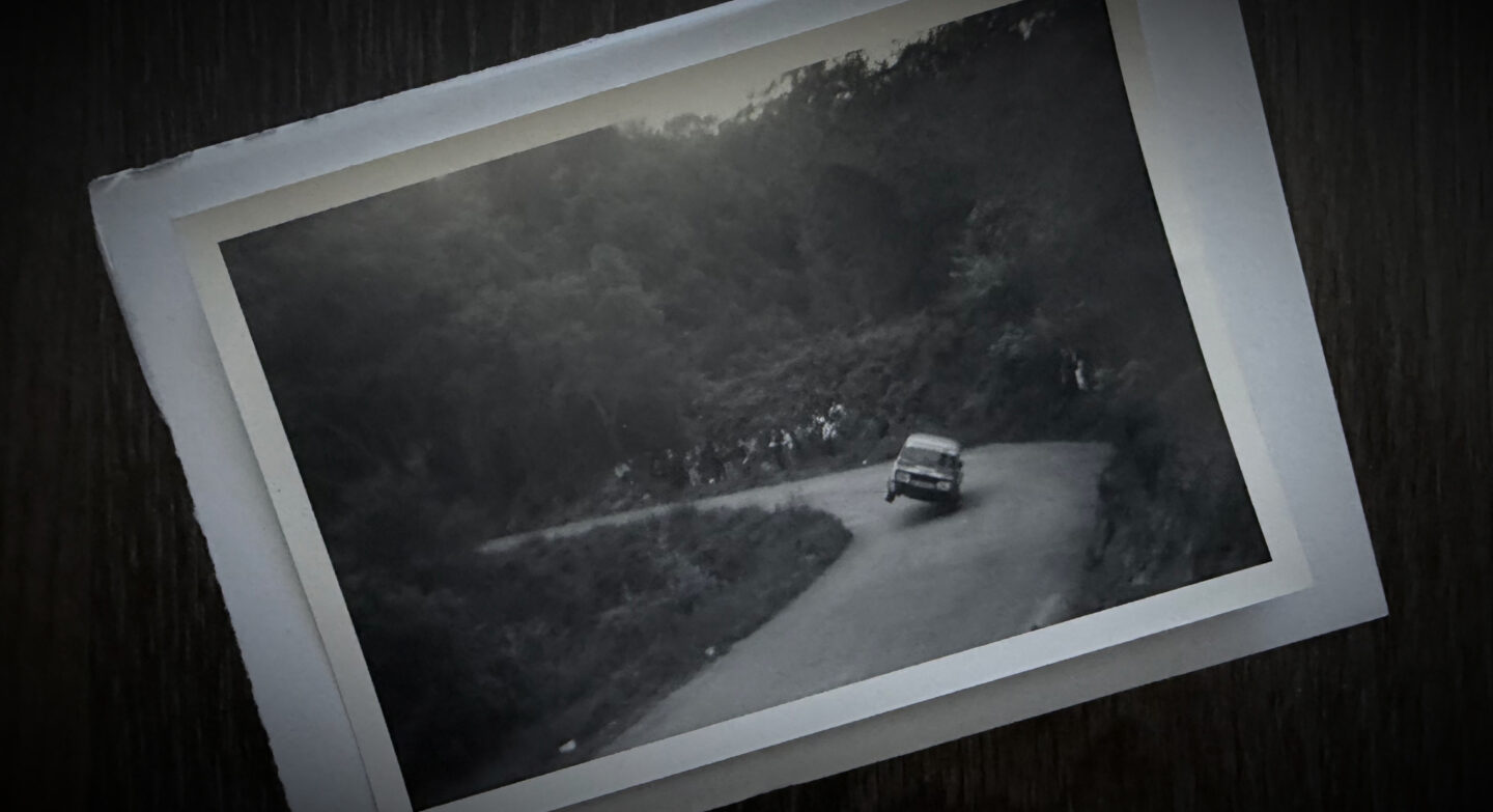 Photograph of an old rally car on two wheels